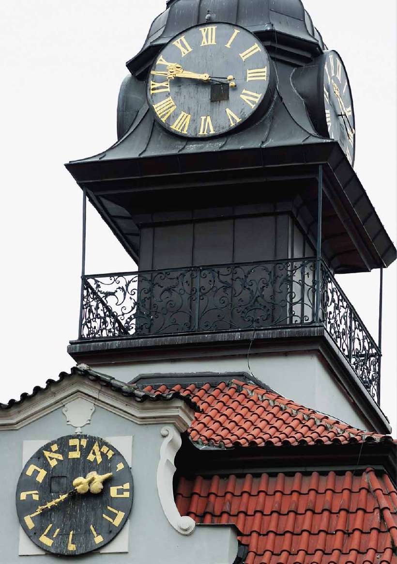 The clock at the bottom with the Hebrew numbers runs counterclockwise. The one on top with the Roman numerals runs 'clockwise'. This spire is located in the Old Jewish Town Hall in Josefov, Prague, Czech Republic.