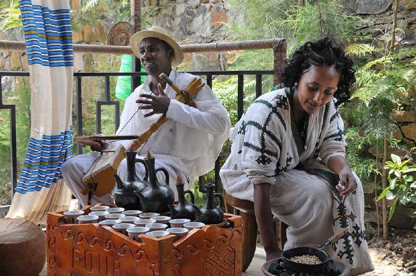 Young Ethiopian woman in traditional clothing preparing coffee while a Man plays on a masenqo. [Bluerain](http://www.shutterstock.com/gallery-136057p1.html?cr=00&pl=edit-00) / [Shutterstock.com](http://www.shutterstock.com/?cr=00&pl=edit-00)