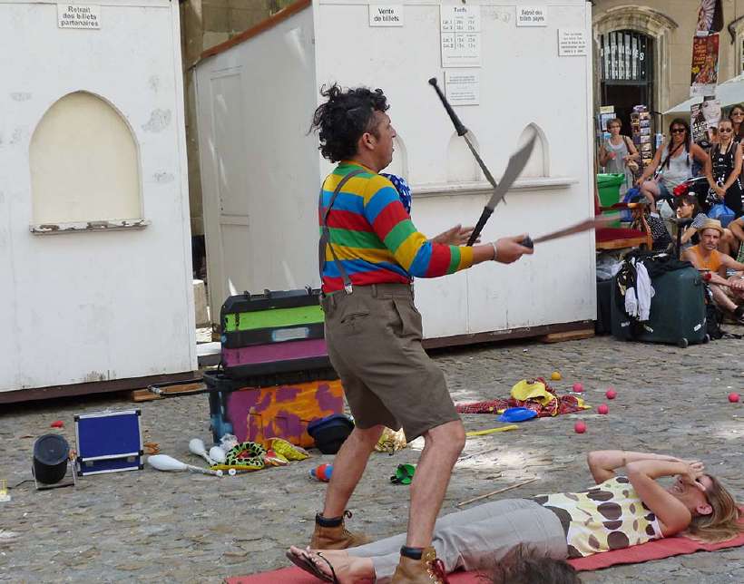 A juggler juggles large knives while another artist lays flat in the path of a possible miss. Avignon Theater Festival in Avignon, France. [sansa55](http://www.shutterstock.com/gallery-679186p1.html?cr=00&pl=edit-00) / [Shutterstock.com](http://www.shutterstock.com/?cr=00&pl=edit-00)