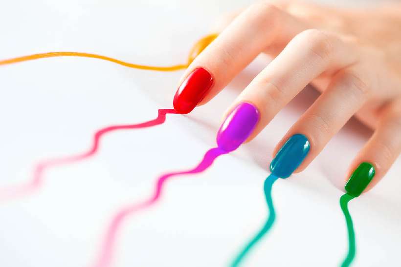 Multicoloured nails of a young woman.