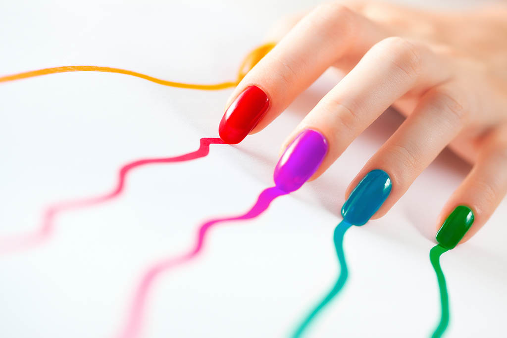 Multicoloured nails of a young woman.