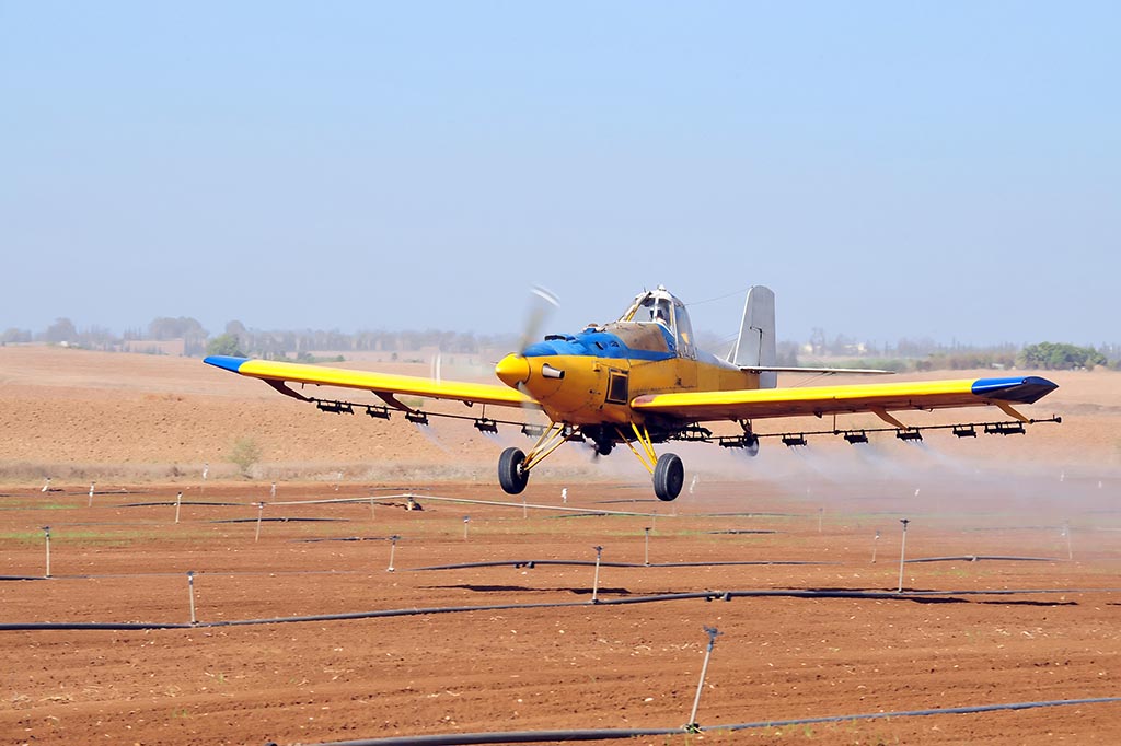 Agricultural aircraft are used for hydroseeding. Here an an agricultural aircraft, sometimes called a spray plane or crop duster, applies chemicals to a field of crops.